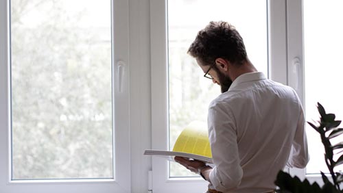 Man reading book as if to study and reflect on leadership skills needed for highly effective teams 